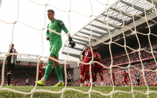 Liverpool's Mohamed Salah celebrates with teammates after scoring their third goal as Newcastle United's Martin Dubravka looks dejected