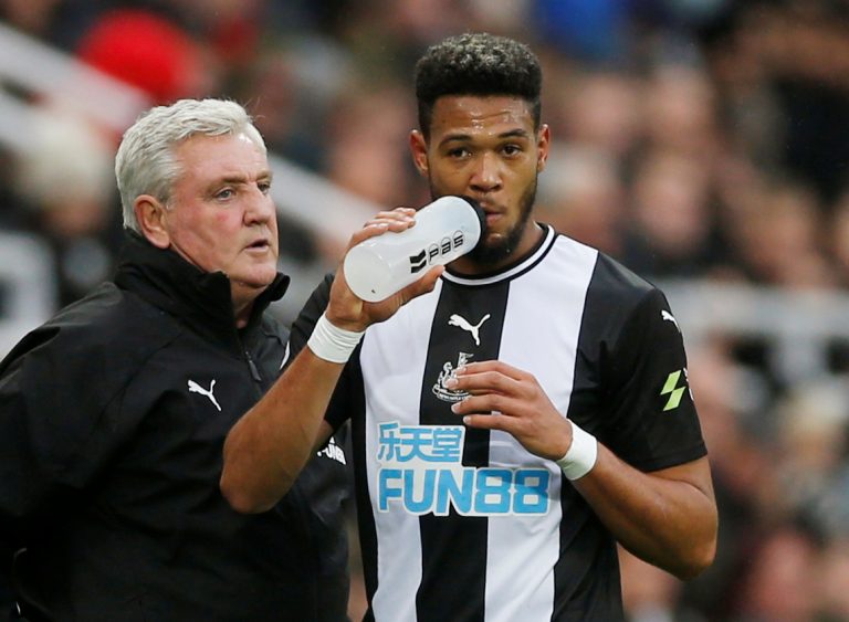 Newcastle United's Joelinton has a drink as manager Steve Bruce looks on v Manchester United