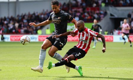 Arsenal's William Saliba is challenged by Rico Henry