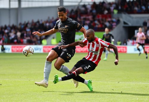 Arsenal's William Saliba is challenged by Rico Henry