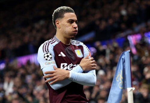 Soccer player pretends to shiver while celebrating goal in claret jersery.