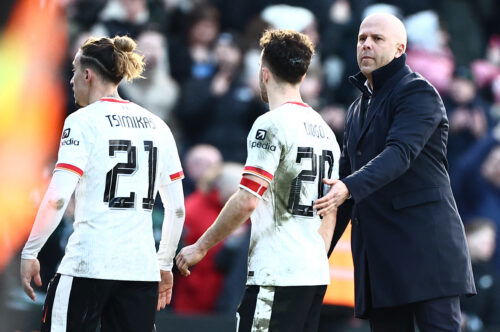 Soccer players in white jerseys consoled by bald manager.