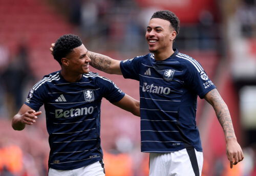 Soccer players in navy jerseys embrace.