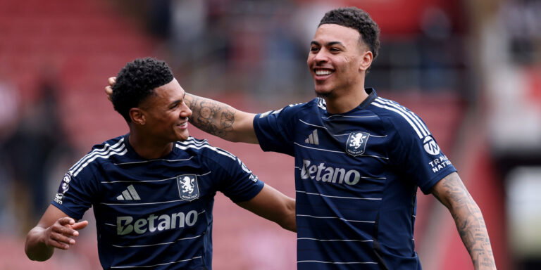 Soccer players in navy jerseys embrace.