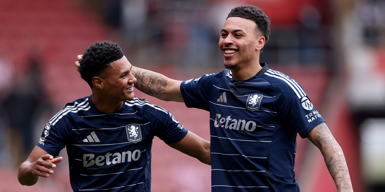 Soccer players in navy jerseys embrace.