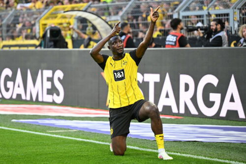 Soccer player celebrates goal in yellow shirt.