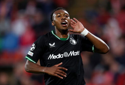 Soccer player with hand to ear.