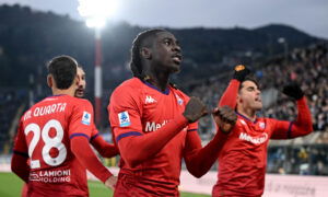 Striker in red shirt celebrates goal.