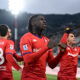 Striker in red shirt celebrates goal.