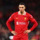 Soccer player in red hands on hips.