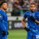 Two soccer players in blue jerseys.
