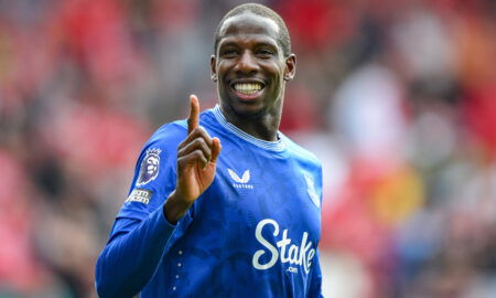 Soccer player in blue jersey smiles.