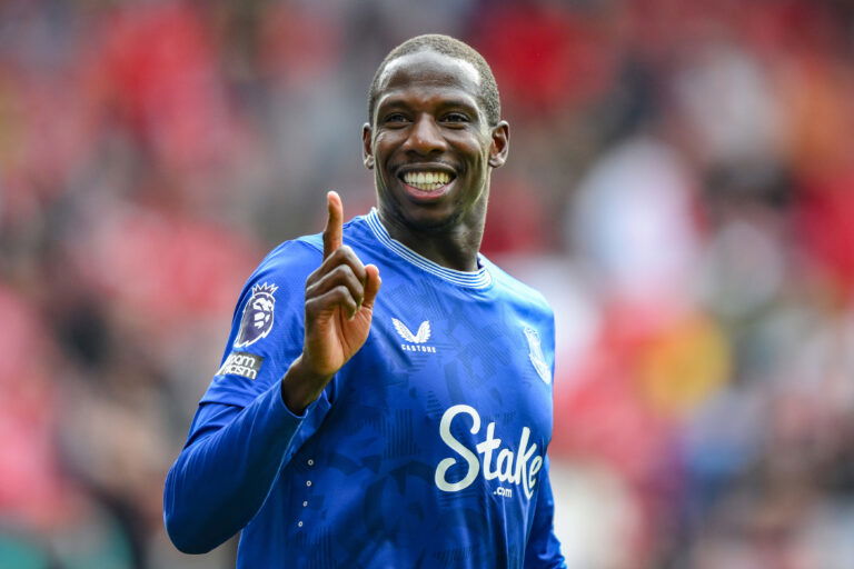 Soccer player in blue jersey smiles.