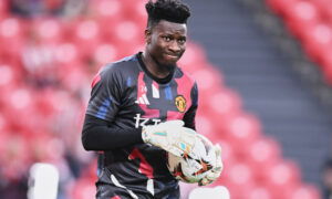 Soccer player with goalkeeper gloves on holds ball.