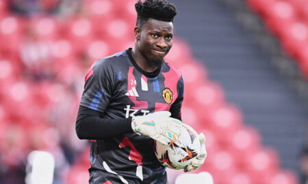 Soccer player with goalkeeper gloves on holds ball.