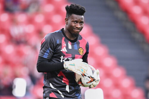 Soccer player with goalkeeper gloves on holds ball.