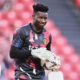 Soccer player with goalkeeper gloves on holds ball.